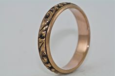 Welcome to Master Piece Jewelers, Specializing in Custom Designs, Engagement Rings, Wedding Bands, Bridal Sets, Diamonds, Colored Stones, and Estate Jewelry. This is a beautiful 14kt black and pink gold with deep hand engraving and floral motif. The ring measures 4.2mm wide and 1.6mm high. Simple and stunning. Ring Specifications - Metal: 14kt Pink Gold (can also be ordered in 10kt, 14kt, or 18kt white, yellow, or rose gold and platinum) - Finger Size: 6.5 or we can size it to fit your finger si Heirloom Etched Wedding Bands, Traditional Wedding Jewelry With Engraving Option, Traditional Wedding Ring With Etched Engraving, Traditional Engraved Ring With Intricate Design For Formal Occasions, Gold Etched Wedding Ring, Elegant Ceremonial Engraved Ring With Intricate Design, Heirloom Etched Engraved Ring For Wedding, Elegant Etched Jewelry For Marriage, Elegant Black Wedding Bands