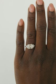 a woman's hand with a diamond ring on it