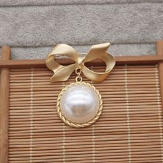 Show off your edgy style with this Gold Bow Brooch! With its eye-catching gold-plated design, intricate Vingate pattern, and sparkling pearl centerpiece, this large brooch is sure to make an impact. An ideal gift for her, this stylishly bold piece is perfect for adding a touch of glamour to any outfit. Ready to turn heads?👌 M A T E R I A L• 18K Gold plated over brass• Faux Pearl• This product is hypoallergenic (nickel free) and tarnish resistant📏 S I Z E• Length: 5.5 cm• Width: 4.5 cm Gold Wedding Brooches Chic Style, Gold Wedding Brooches In Chic Style, Chic Gold Wedding Brooch, Gold Chic Wedding Brooches, Chic Gold Wedding Brooches, Gold Pearl Brooches For Party, Chic Gold Brooches For Party, Gold Brooch Pins For Party, Pearl Centerpiece