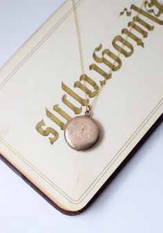 c. 1890s tidy, smaller sized round locket in warm 1/4 gold (higher gold content than gold-fill) with decorative cursive "H" on one side and initials "A.F.M." on the other. interior compartments contain original removable frame pieces for storing photos or other tiny keepsakes (a lock of hair, a mantra, etc). paired with an 18" modern 14kt goldfill chain hallmarked for Carter, Qvarnstrom & Remington Company. and "Joint Gold, 1/4 Gold" 7/8" dia. excellent condition. --------- boxes and photo props shown not included. jewelry is shipped in padded presentation boxes. --------- antique and vintage lockets are sourced from a variety of decades. Most are 1890-1950 and were made in Rhode Island or Massachusetts (where much of the costume jewelry from the early-mid 20th century in the US was made!) Vintage 14k Gold Locket Necklace Stamped 14k, Vintage 14k Gold Locket Necklace, Victorian Round Locket Necklace Stamped 14k, Classic Round Pendant Locket Necklace With Vintage Charm, Classic Vintage Charm Locket Necklace, Victorian Engraved Rose Gold Locket Necklace, Vintage 14k Gold Locket Necklace With Vintage Charm, Vintage Heirloom Locket Necklace With Charm, Victorian 14k Gold Locket Necklace