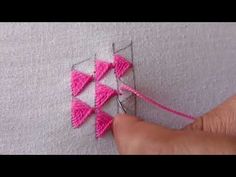 someone is stitching something with pink thread