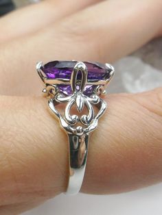 Natural Purple Amethyst RingSmall Fat Oval Design#D111 Inspired by Gothic designs, this stunning antique reproduction ring is crafted in sterling silver. This gorgeous ring is set with a flawless oval-cut natural purple amethyst. The stunning 3 carat weight gemstone is 11mm x 9mm. The band is marked 925 for sterling silver. Notice the beautiful silver filigree swirl setting and band. The bold style travels around the base of the gem and morphs into a solid band. The stunning gem rises above the Jewelry Store Design, Purple Amethyst Ring, Buy List, Gothic Design, Gorgeous Ring, Bold Style, Amulets, Engraved Items, Gothic Jewelry