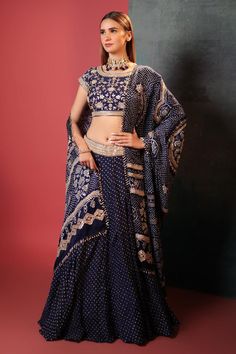 Blue attached can-can silk lehenga with all over bandhani pattern. Paired with a padded floral gota embroidered blouse and bandhani dupatta, highlighted with gota and cutdana.
Components: 3
Pattern: Woven, Embroidery
Type Of Work: Bandhani, Gota
Neckline: Round Neck
Sleeve Type: Short Sleeves
Fabric: Silk
Color: Blue
Other Details: 
Lehenga:
Attached can-can
Gota embroidered broad waistband
Length: 42 inches
Blouse:
Padded
Back tie-up detailing
Length: 14 inches
Dupatta:
Beaded and tassel work b Traditional Indigo Sets With Dupatta, Traditional Silk Palazzo Set With Bandhani Print, Wedding Indigo Sets With Dupatta, Indigo Wedding Sets With Dupatta, Indigo Wedding Set With Dupatta, Indigo Navratri Set With Dupatta, Indigo Sets With Dupatta For Navratri, Bollywood Indigo Sets With Zari Work, Bollywood Style Indigo Sets With Zari Work