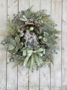 a wreath with an image of mary and baby jesus in the center, surrounded by greenery