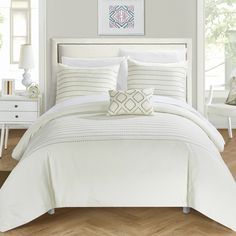 a bed with white sheets and pillows in a room