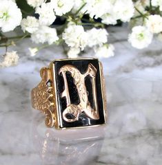 a close up of a ring on a table with white flowers in the back ground