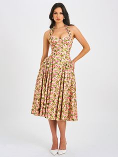 Behold our Niya maxi dress, a stunning union of style and ease. Delicately crafted from a charming floral print fabric, it exudes feminine allure with every step. The drop waist design imparts a contemporary silhouette, while padded cups ensure a flattering fit. Practicality meets elegance with convenient pockets discreetly integrated into the design. Structured with built-in bones and hard mesh supporting the hemline, it promises both form and function. Seamlessly finished with an invisible zip Feminine Halter Neck Dress With Fitted Bodice, Floral Print Midi Dress With Fitted Bodice, Midi Length Floral Dress For Garden Party, Feminine Fitted Floral Print Maxi Dress, Fitted Feminine Floral Print Maxi Dress, Feminine Fitted Maxi Dress With Floral Print, Summer Midi Dress With Pleated Bodice And Fitted Waist, Sleeveless Rose Print Maxi Dress For Garden Party, Spring Rose Print Dress With Fitted Bodice