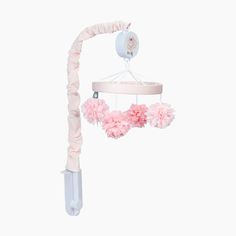 a pink baby crib mobile with flowers hanging from it's side and a white background