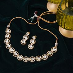 Step-in to the aura of timeless elegance with this must-have piece adding a touch of class to any ensemble! Embellish your look with subtle sophistication and enhance your style with this exquisite set crafted with luxurious and dazzling polki jadau kundan stones. The set includes a necklace and a pair of push-back earrings. Approximate earrings length is 1.5". Gold-plated on high-quality brass as base metal. In-stock & ready-to-ship. *Please Note: We use faux stones and beads in all of our jewe Gold Kundan Sets For Reception, Elegant Festive Jewelry Sets With Gota Work, Party Temple Jewelry Kundan Necklace With Gota Work, Party Kundan Necklace With Gota Work In Temple Style, Elegant Kundan Jewelry Sets With Gota Work, Festive Kundan Necklace Hand Set, Festive Kundan Necklace With American Diamond Stone Work, Festive Hand Set Kundan Necklace For Celebration, Diwali Festive Gold-plated Kundan Necklace