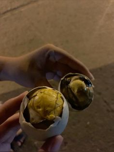 two hands holding an egg with ice cream in it