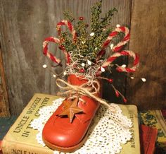 a pair of red shoes sitting on top of a book next to a christmas tree