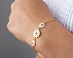 Presenting our lovely Silver Daisy Bracelet, the ideal present for any holiday, especially Christmas. The daisy pendant serves as the bracelet's striking focal point thanks to its unique and delicate design. Everybody will be able to wear the bracelet comfortably because it is fully adjustable to fit any wrist size. This bracelet was made from premium materials, making it strong and long-lasting. The daisy pendant is expertly crafted with attention to every last detail, giving it a lifelike appearance that brings a hint of natural charm to any ensemble. The bracelet itself has a strong and reliable clasp that makes sure it will stay put.   * Materials: Gold, Rose gold, Silver   * Silver Daisy It weighs about 5 gr. (Chain Included)   * Silver Daisy Bracelet with white and yellow enamel proc Flower Charm Bracelet Jewelry For Friendship, Flower Charm Bracelet For Friendship, Friendship Bracelet With Flower Charm, Flower Charm Bracelet As A Gift, White Flower Charm Jewelry For Friendship, White Jewelry With Flower Charm For Friendship, Mother's Day Gift Bracelets With Flower Shape, Gift Flower-shaped Bracelet For Mother's Day, White Bracelet Jewelry Gift For Mom