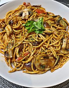 a white plate topped with pasta and mushrooms