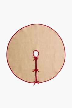 a round table mat with a red ribbon around it and a white circle on the side