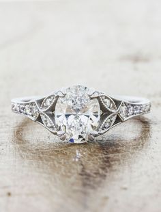 an antique style diamond engagement ring on a table