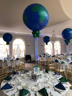 the tables are set with plates and silverware for an earth themed celebration at this event