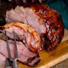 a large piece of meat sitting on top of a cutting board next to a knife