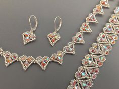 a necklace and earring set made with swarozak crystal stones on a gray surface