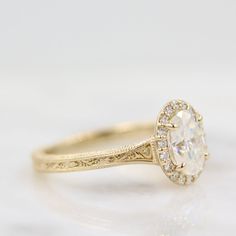 a close up view of a diamond ring on a white surface with the center stone surrounded by small diamonds