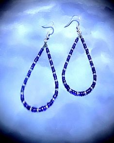 These beautiful 2 3/4" earrings are made with blue and purple and silver seed beads. These beads are a nice embellishment to the classic teardrop hoop earrings. These teardrop earrings are very comfortable because they are so lightweight.  Hoop earrings are classic, and these are teardrop hoops, with a pattern that makes a statement. You can't go wrong with these earrings! They are great all year round. These would be great on to wear on July fourth! They come in a box for easy gift giving too. Silver Teardrop Jewelry With Tiny Beads, Blue Teardrop Hoop Earrings With Dangling Beads, Blue Teardrop Jewelry With Silver Beads, Blue Beaded Hoop Earrings Gift, Gift Blue Beaded Hoop Earrings, Blue Hoop Earrings With Dangling Beads Gift, Blue Dangle Hoop Earrings With Tiny Beads, Blue Drop Earrings With Silver Beads, Sterling Silver Teardrop Beaded Earrings With Dangling Beads