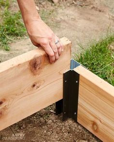 a person is working with some wood to build a fence post and bench rail for the yard