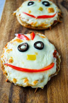 two cookies decorated to look like faces with googly eyes and carrots on them