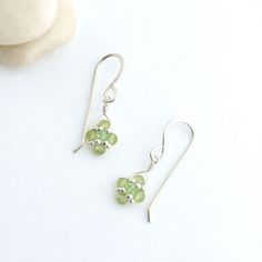 Our dainty peridot earrings feature the beautiful green gemstone and dangle from handmade sterling silver ear wires.  The cheerful gems are hand woven into a diamond shape with small silver beads and a sparkling green crystal sits at the center.  The combination enhances the gemstones natural beauty making the pair an ideal August birthstone accessory and an exquisite 16th anniversary gift for her!   The dainty design adds a touch of elegance and a pop of color that will accentuate any outfit. W Peridot Dangle Earrings For May Birthstone, Nickel Free Sterling Silver Earrings For Birthday, Nickel-free Sterling Silver Earrings For Birthday, Green Peridot Wire Wrapped Jewelry, Delicate Sterling Silver Birthstone Earrings, Lime Green Jewelry With Matching Earrings For Gift, Peridot Dangle Earrings With Ear Wire, Green Peridot Earrings For Anniversary, Lime Green Sterling Silver Birthstone Jewelry