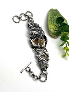 "Artisan Amber gemstone bracelet Hand-made Sterling Silver 925 Stones used: Baltic Amber, Abalone Shell, Pearls, Peridot, Amethyst Amber stone -Height - 30mm (with bail), Width - 22mm Length - 8 1/2 inches, good for 7 and 7 1/2 inches Heigh of bracelet - 1 3/8\" Unique Handcrafted One-of a-kind Design Bracelet Each Piece of Jewelry in my Collection is Absolutely One of a Kind! When you start wearing a piece of my jewelry you will fall in love with it more and more each day and feel that good Ene Unique Hand Cast Bracelet Jewelry, Handmade Unique Sterling Silver Bracelet, Unique Adjustable Sterling Silver Bracelet, Spiritual Hand Cast Bracelets As A Gift, Hand Forged Silver Brutalist Jewelry, Hand Cast Brutalist Metal Jewelry, Hand Cast Metal Brutalist Jewelry, Brutalist Hand Cast Metal Jewelry, Metal Gemstone Bracelets For Gifts