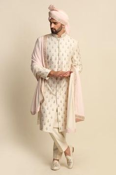 Ivory kurta with floral embroidered zardozi work butis. Paired with off-white kurta and churidar. Comes with an ombre stole, pagdi.
Component: 5
Pattern: Embroidered
Type Of Work: Floral motifs, Zardozi
Neckline: Mandarin collar
Sleeve Type: Full sleeves
Fabric: Raw Silk, Silk, Crepe
Color: White,Beige
Other Details: 
Side slits
Ombre stole
Embroidered motifs
Front button placket
Note: For juttis, please get in touch with the customer service
Occasion: Wedding, Destination Wedding - Aza Fashions Indian Wedding Clothes For Men, Embroidered Sherwani, Gents Kurta Design, Sherwani Groom, Gents Kurta, Zardozi Work, Kurta Set For Men, Sherwani For Men, Embroidered Motifs