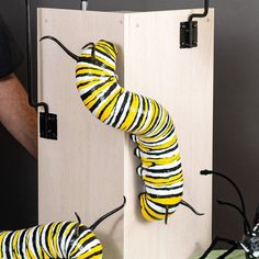 a close up of a caterpillar attached to a wooden box with wires on it