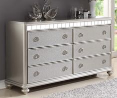 a silver dresser in a room with grey walls