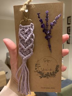 two lavender flowers are being held in front of a card