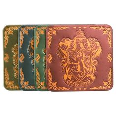 four different colored coasters with an image of a lion on one side and a crest on the other