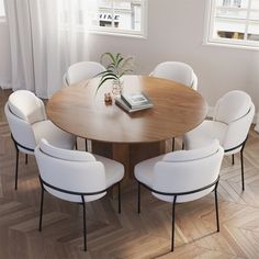 a round table with white chairs and a book on it in front of two windows