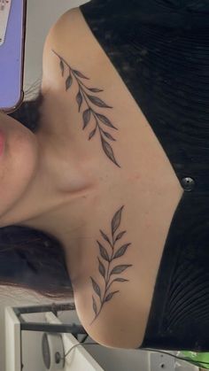 a woman with a tattoo on her chest is looking at the camera while she's taking a selfie