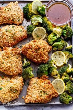 chicken and broccoli on a baking sheet with dipping sauce in the middle, ready to be eaten