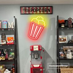 a popcorn machine sitting on top of a counter next to shelves filled with snacks and other items