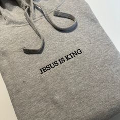 Jesus is King Embroidered T-Shirt, Embroidered Hoodie, Christian Based Clothing, Faith Apparel, Stitched Pullover hooded sweatshirt - Bible Gift Minimalist  - 80% Cotton - 20% Polyester - 7.8 oz/y² Shop: Tiny home shop located in California. All garments are printed to order, handcrafted individually.  I will never use third party cheap labor print shops or mass production drop shippers.  Every Garment is designed, printed, and packaged independently by me. Thank you for supporting someone who i Gray Hoodie Sweatshirt With Embroidered Logo, Gray Embroidered Logo Hoodie Sweatshirt, Winter Hoodie With Letter Embroidery And Relaxed Fit, Gray Long Sleeve Hoodie With Embroidered Logo, Streetwear Hoodie With Embroidered Text In Relaxed Fit, Cotton Hoodie With Letter Embroidery And Relaxed Fit, Relaxed Fit Cotton Hoodie With Letter Embroidery, Embroidered Text Hoodie For Streetwear, Winter Crew Neck Hoodie With Embroidered Text