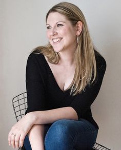 a woman sitting on top of a wire basket smiling at the camera with her legs crossed