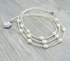 "Triple pearl necklace, layering multi strand necklaces, Mother's day gift, gift for bride, wedding pearl jewelry, white rice pearls, freshwater pearls. Length: 17.5\" or 44 cm by shorter strand. Please see photos on the model. Small rice shaped freshwater pearls measure 3X4 mm, they are white color with cream overtone, lustrous. You can see they are made by nature, because every bead has its own individuality, no 2 beads look alike. I used larger rice shaped freshwater pearl beads for the centr White Double Strand Pearl Necklace With Pearl Drop, Double Strand Pearl Necklace For Wedding, White Double Strand Pearl Necklace For Anniversary, White Pearl Pendant Necklace For Wedding, Double Strand Pearl Embellished Necklace For Wedding, Delicate Beaded Necklace With Pearl Pendant For Wedding, Delicate Pearl Pendant Beaded Necklace For Wedding, Delicate Beaded Necklace With Pearl Charm For Wedding, White Beaded Necklaces With Pearl Charm For Weddings