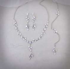 a necklace and earring set is shown on a white surface with the jewelry in it