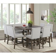 a dining room table with white chairs and a potted plant on the end shelf