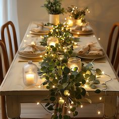 the table is set with candles and greenery