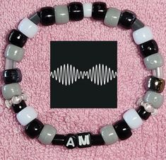 a black and white beaded bracelet with the word ma written in silver letters on it