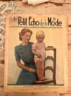 an old fashion magazine with a woman holding a baby on it's lap next to a crochet doily