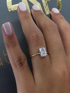 a woman's hand with a diamond ring on it