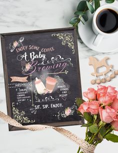 a chalkboard sign next to pink roses and a cup of coffee on a table