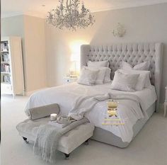 a bedroom with a chandelier hanging from the ceiling and a bed in the middle