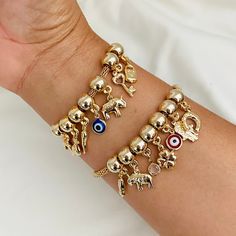 Our protection gold elephant bracelet is ideal because it has several charms of protection and good luck, such as the hand of Hamsa, evil eye, clover, horseshoe, elephant, and some more that, in addition to protecting you and keeping you away from the Negative vibes are also for luck, these dangling charms make it look spectacular! Choose yours, and I will prepare it for you! Measurements: - Length: 7 inches with two extension inches  -  Link Width: 3mm - Charms have a width range of 4- 13mm. Pl Yellow Gold Charms Bracelet For Good Luck, Yellow Gold Good Luck Charms Bracelets, Adjustable Gold Evil Eye Bracelet With Charms, Gold Symbolic Bracelet With Evil Eye, Symbolic Gold Bracelets With Evil Eye, Gold Plated Bracelet With Dangling Charms, Gold Beaded Bracelets With Charms For Friendship, Gold Evil Eye Bracelet With Charms For Gift, Gold Evil Eye Bracelet With Charms As Gift