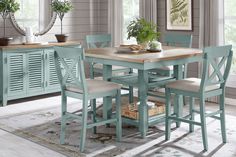 a dining room table with four chairs and a potted plant in the center on top of it